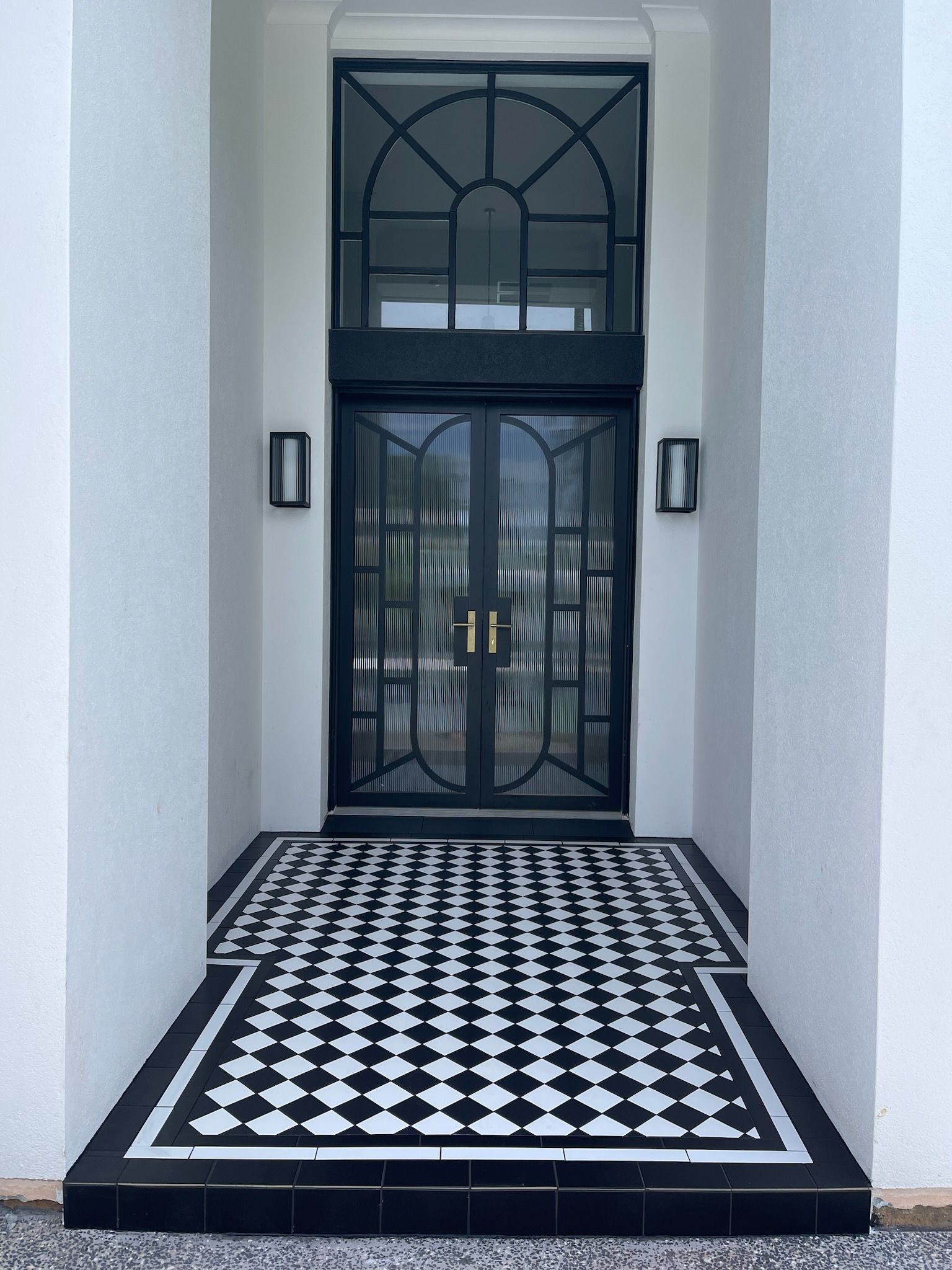 A black and white tile floor in front of a door