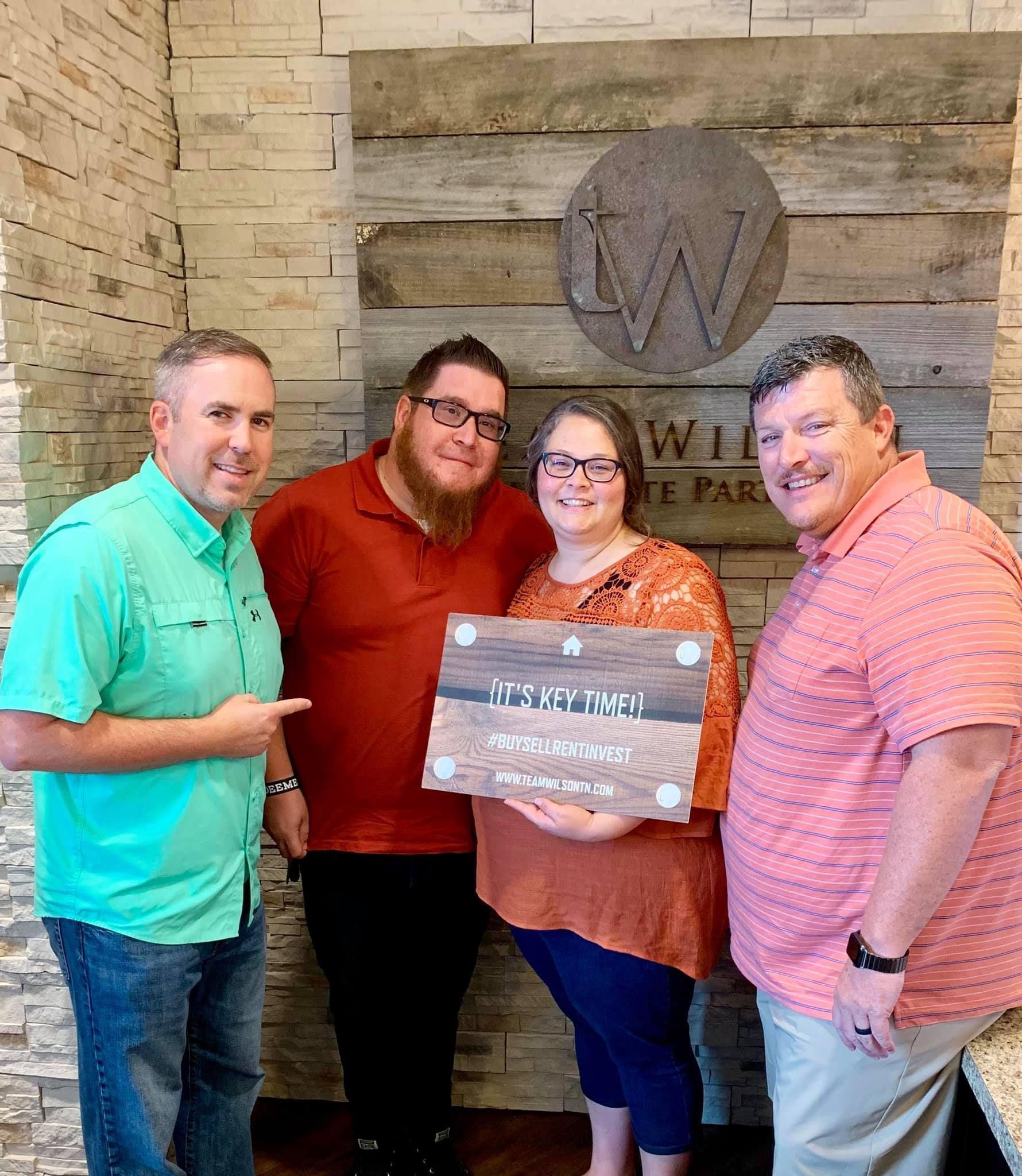 Real estate agents and clients holding