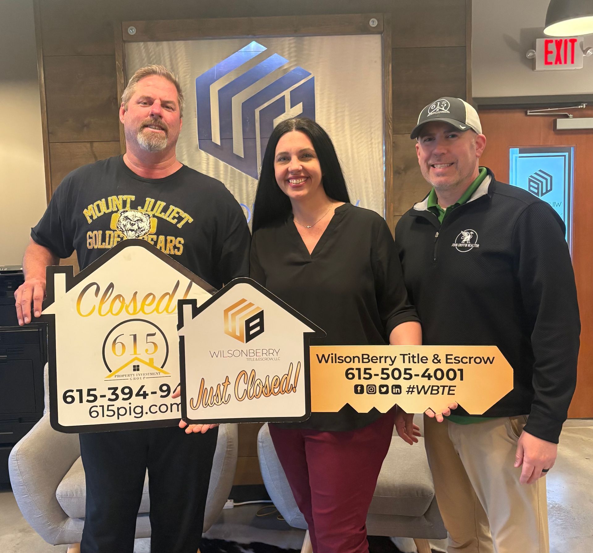 Real estate agent and clients holding 