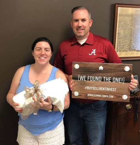 Real estate agent and client holding