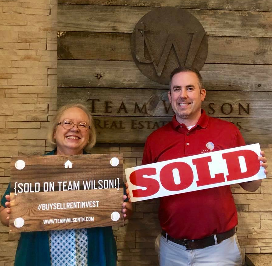 Real estate agent and client holding