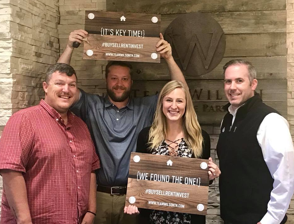 Real estate agents and clients holding