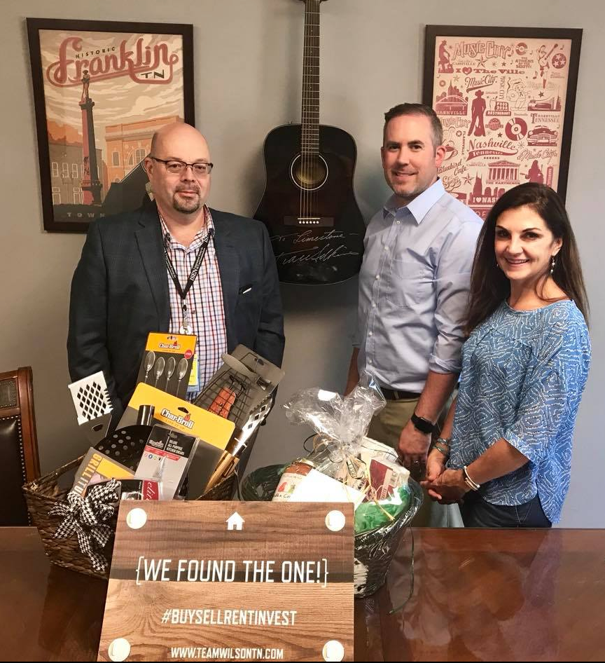 Real estate agent and clients holding