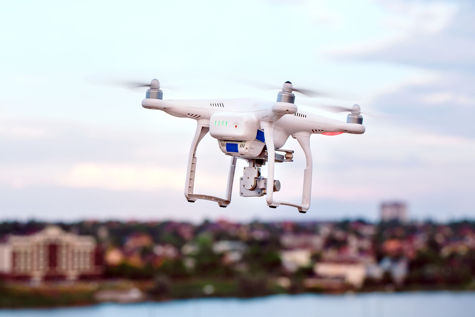 Video camera setup in a home office with a monitor, light, and plants.