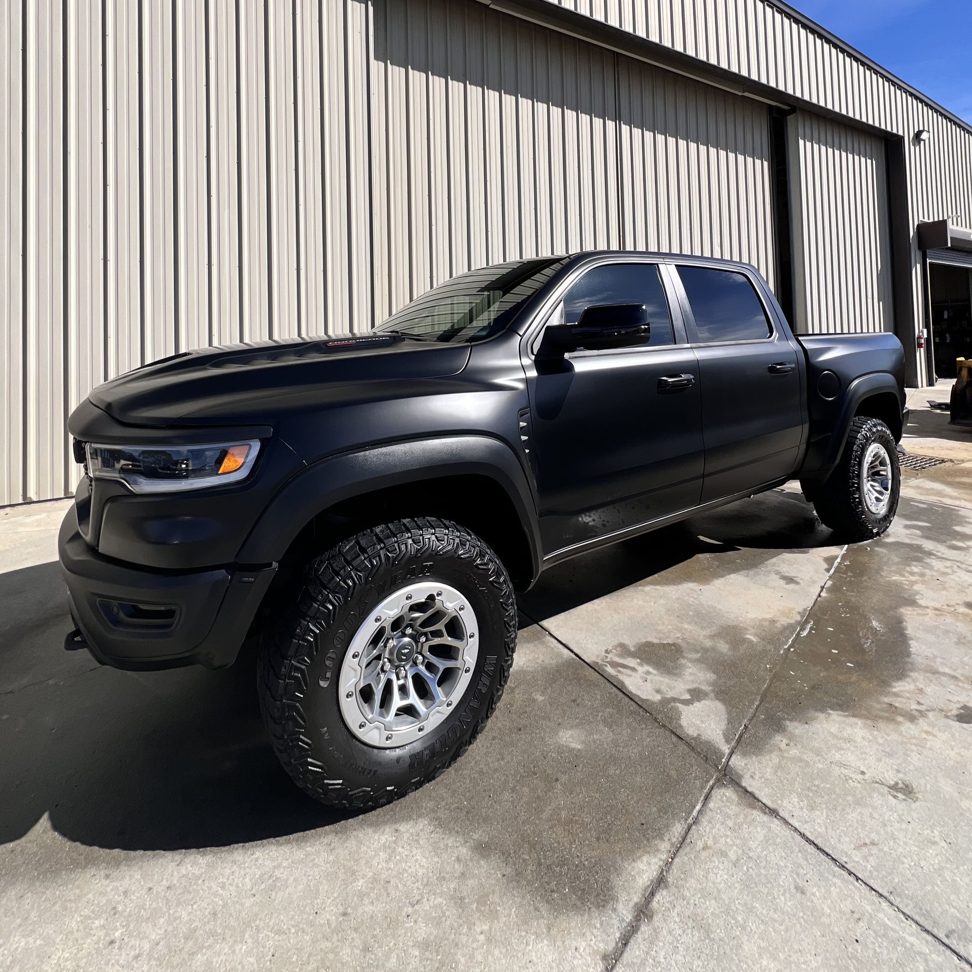 A person is holding a bottle of gwash in front of a car