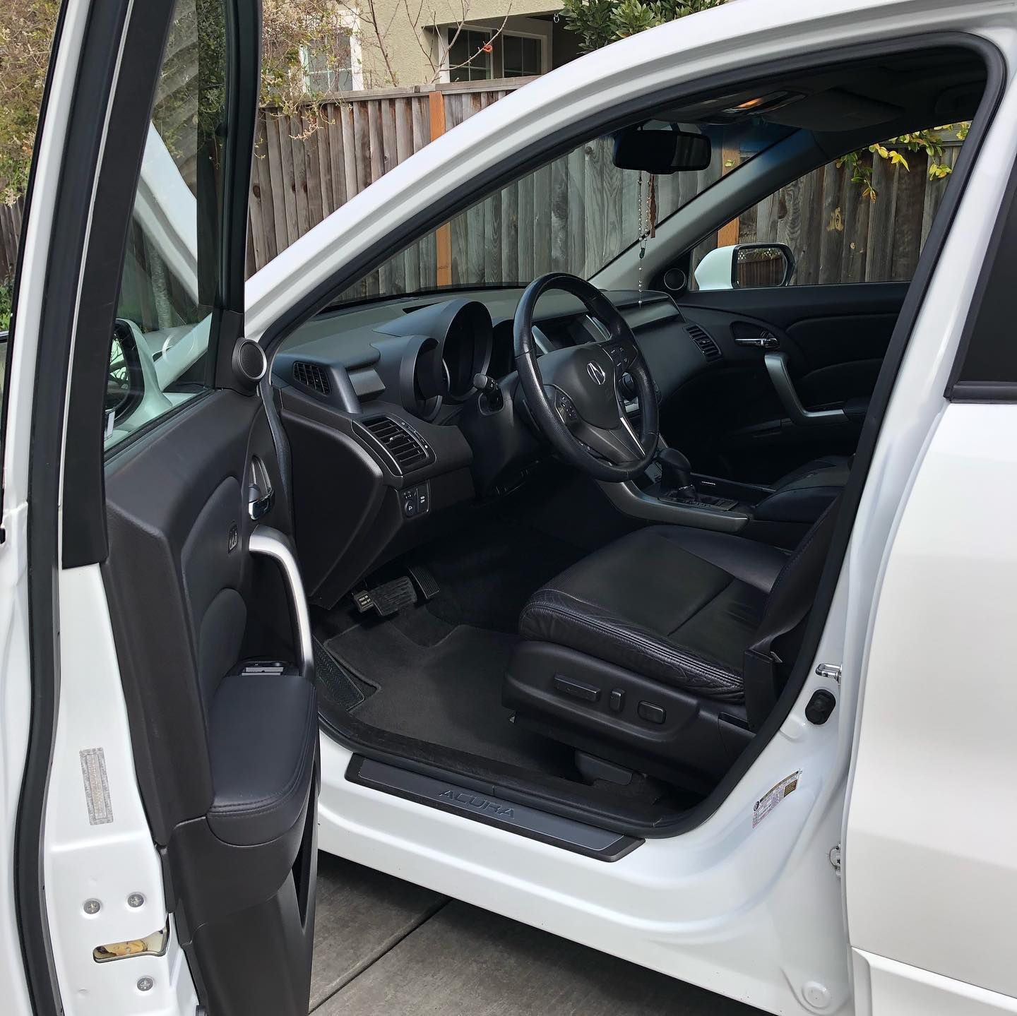The inside of a white car with the door open