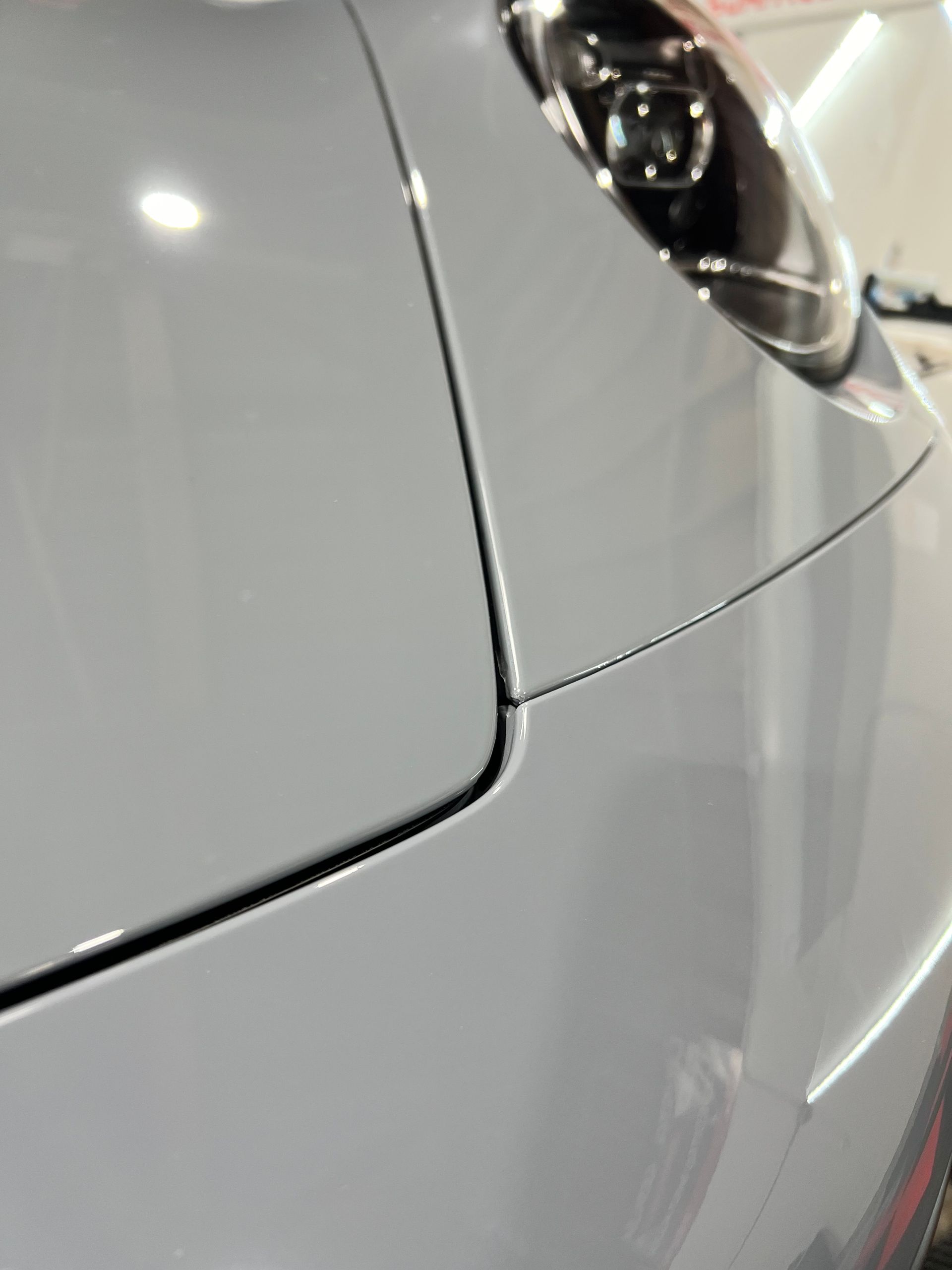 A close up of a car 's hood and headlight