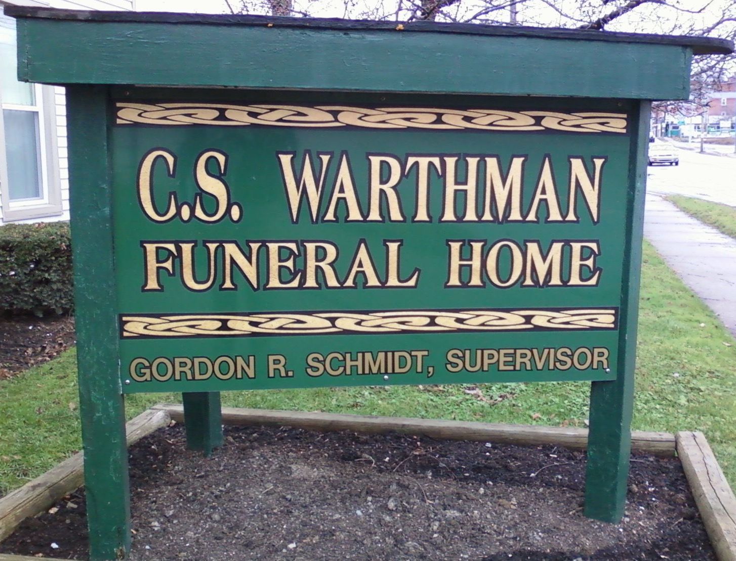 A green sign for c.s. wartman funeral home