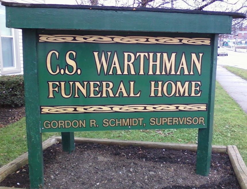 A green sign for c.s. wartman funeral home