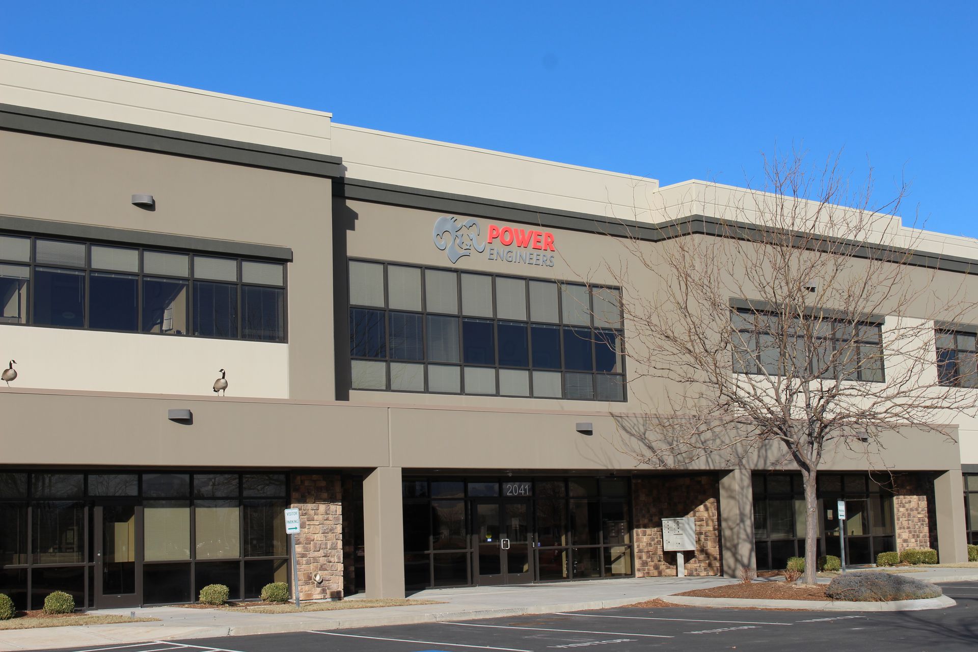 A large building with a lot of windows and a tree in front of it