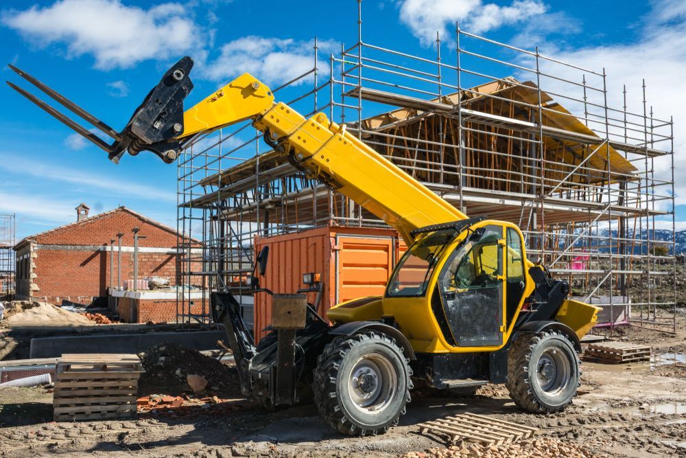A Yellow Forklift is Parked in Front of a Building Under Construction — NRS Scaffolding Pty Ltd in Yamba, NSW