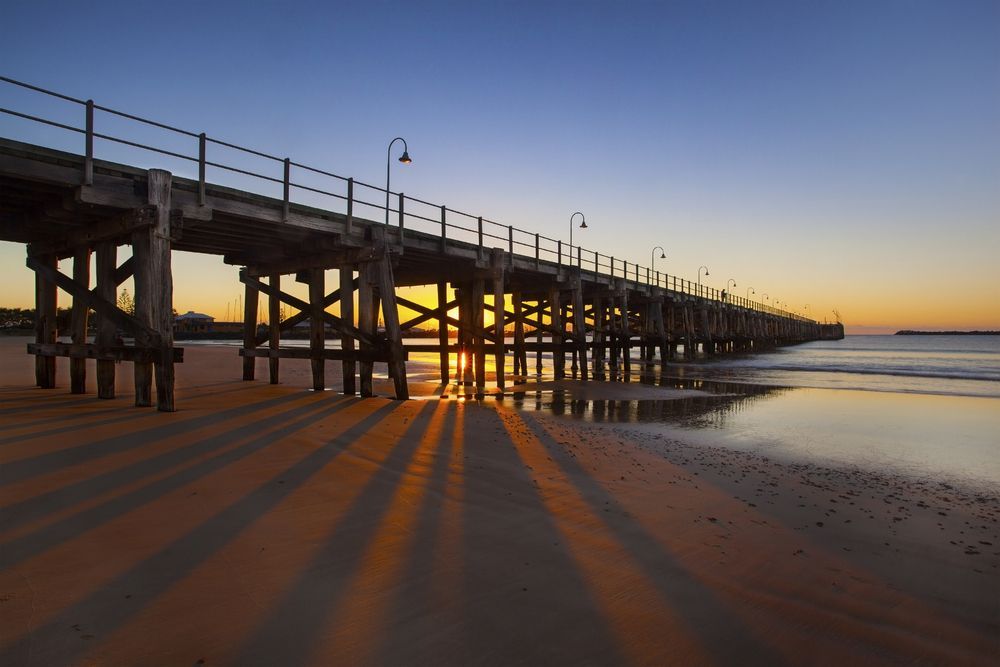 A Pier Leading Into the Ocean at Sunset — NRS Scaffolding Pty Ltd in Coffs Harbour, NSW