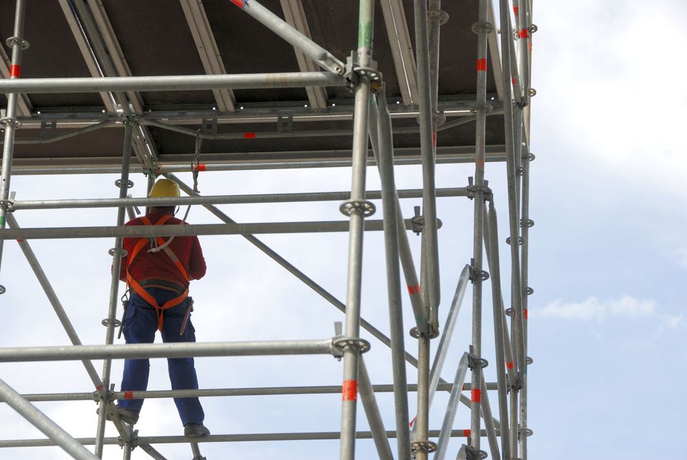 Worker on Scaffolding Wearing Safety Harness; Blue Sky Background — NRS Scaffolding Pty Ltd in Harrington, NSW
