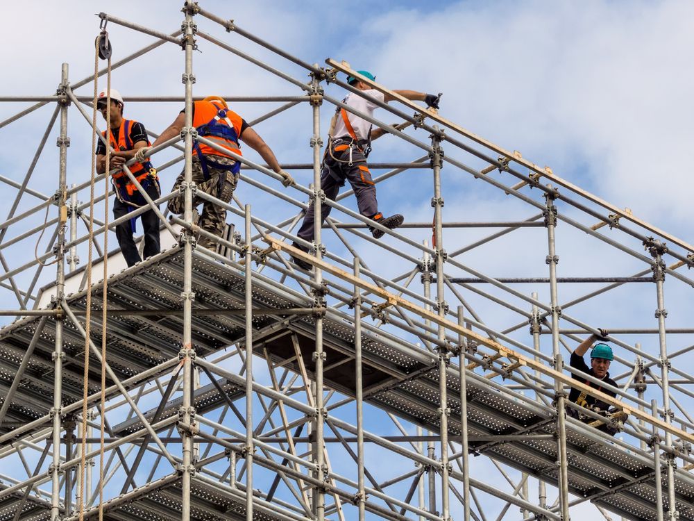 Construction Workers in Orange and Blue Vests on Scaffolding — NRS Scaffolding Pty Ltd in Wingham, NSW