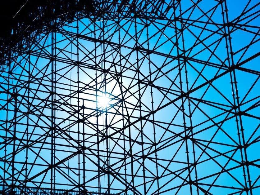 Black Scaffolding Against a Bright Blue Sky, With the Sun in The Background — NRS Scaffolding Pty Ltd in Nambucca Heads, NSW