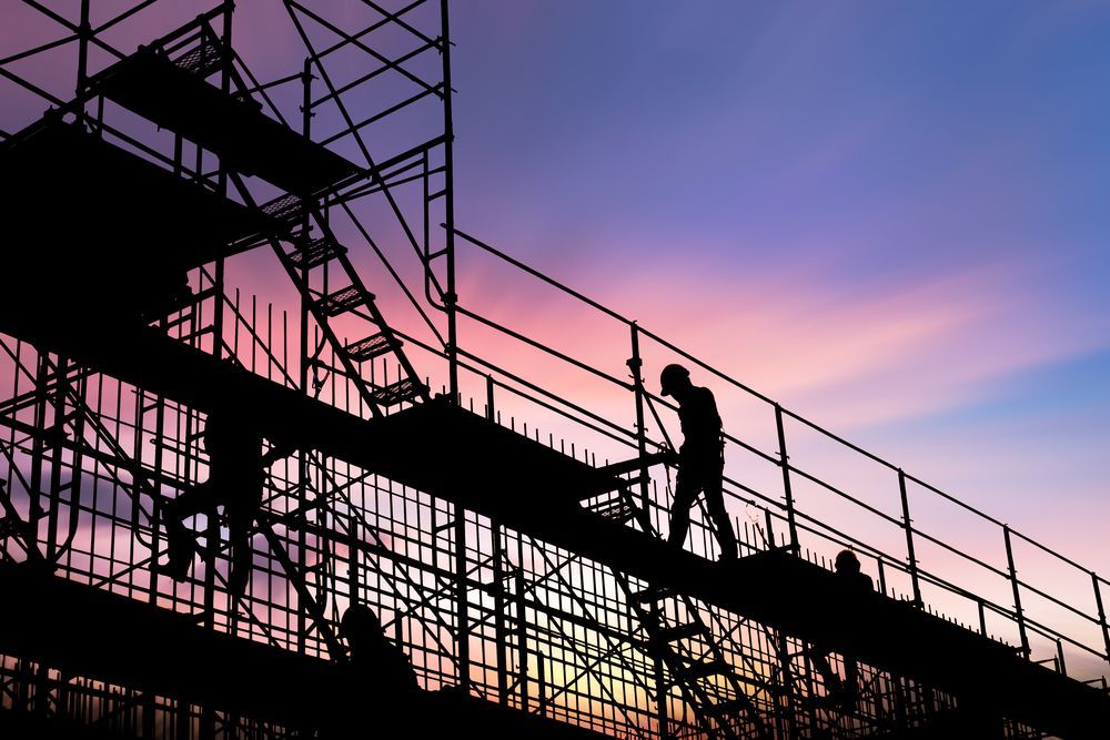 Silhouetted Construction Workers on Scaffolding at Sunset; Pink and Purple Sky — NRS Scaffolding Pty Ltd in Kempsey, NSW