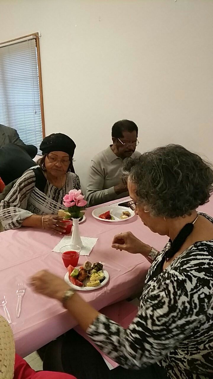 A group of people are sitting at a table eating food.