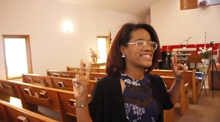 A woman in a church giving the peace sign