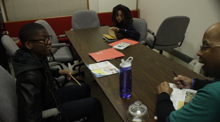A group of people are sitting around a long table