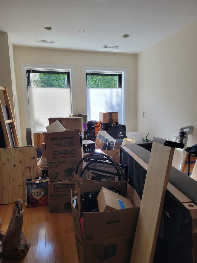 A living room filled with lots of boxes and furniture.