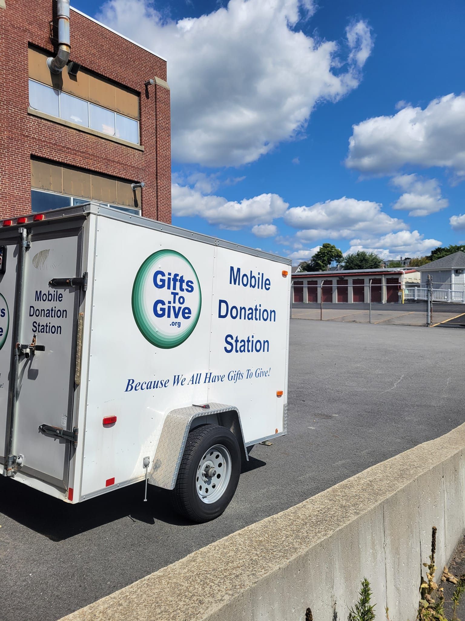 A white trailer with the words gifts to give mobile donation station on it
