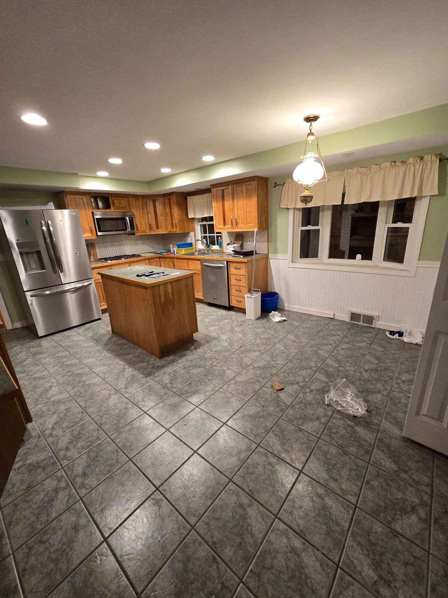 A kitchen with stainless steel appliances and wooden cabinets.