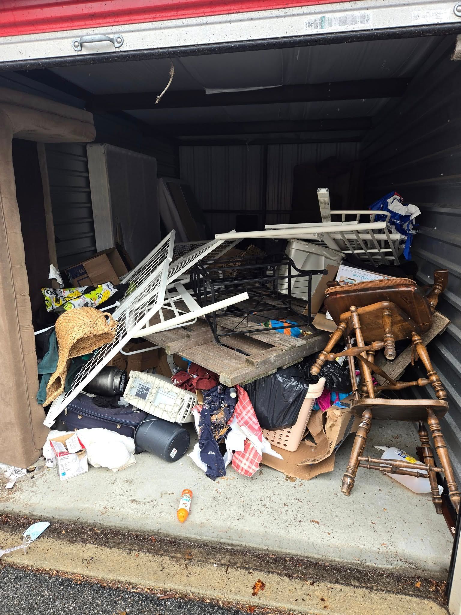 A storage shed filled with lots of furniture and junk.