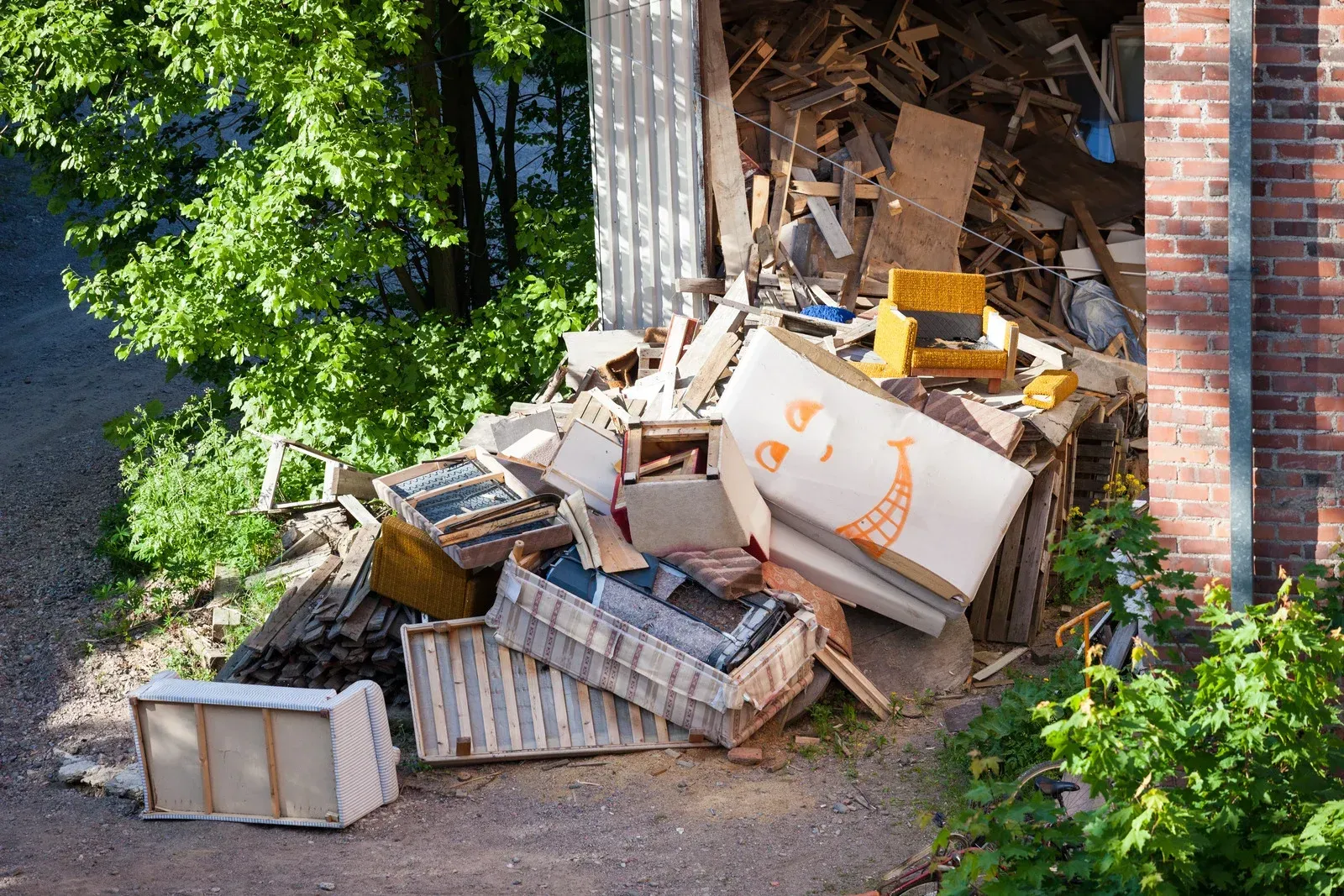 A pile of trash is sitting in front of a brick building.