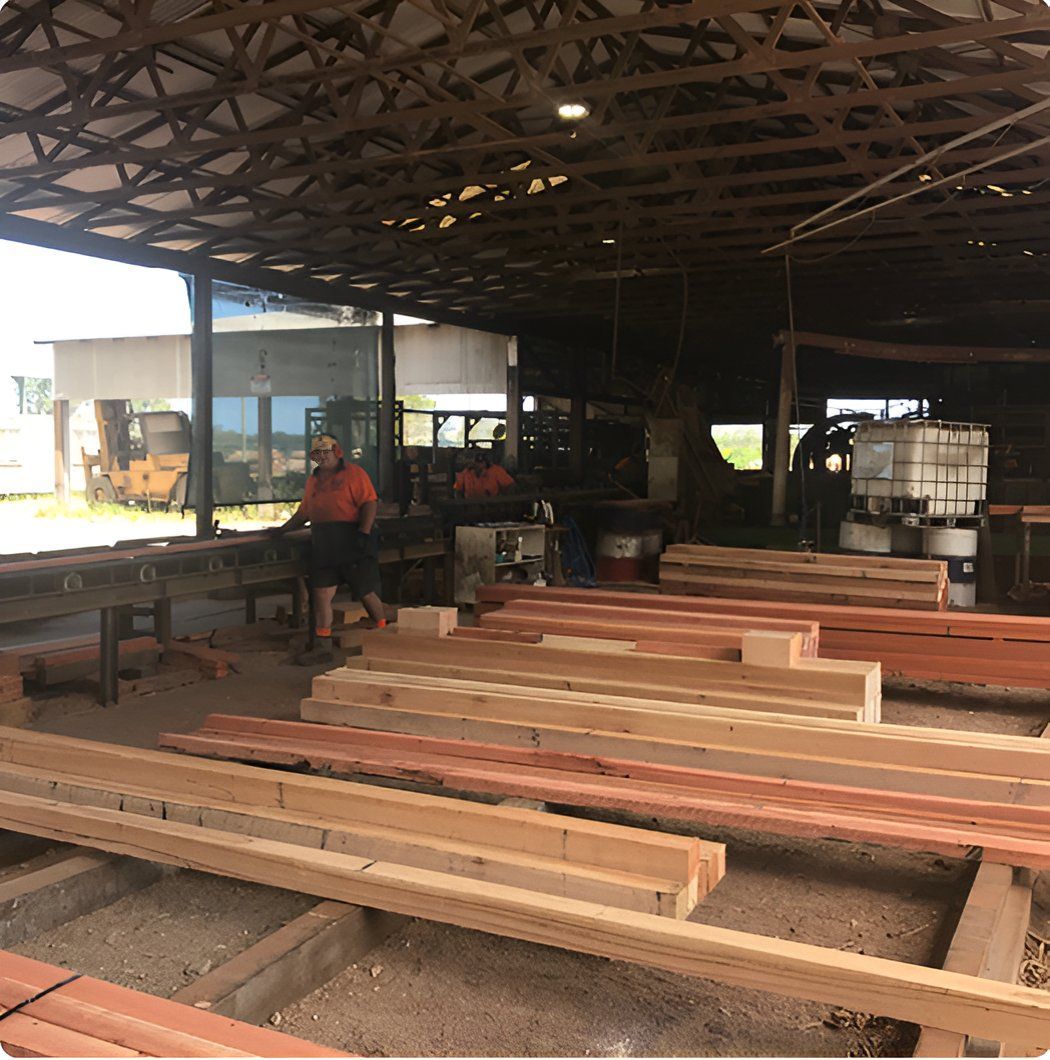 A Warehouse Filled With Lots Of Wooden Beams — Machin's Sawmill Pty Ltd In Wingham, NSW