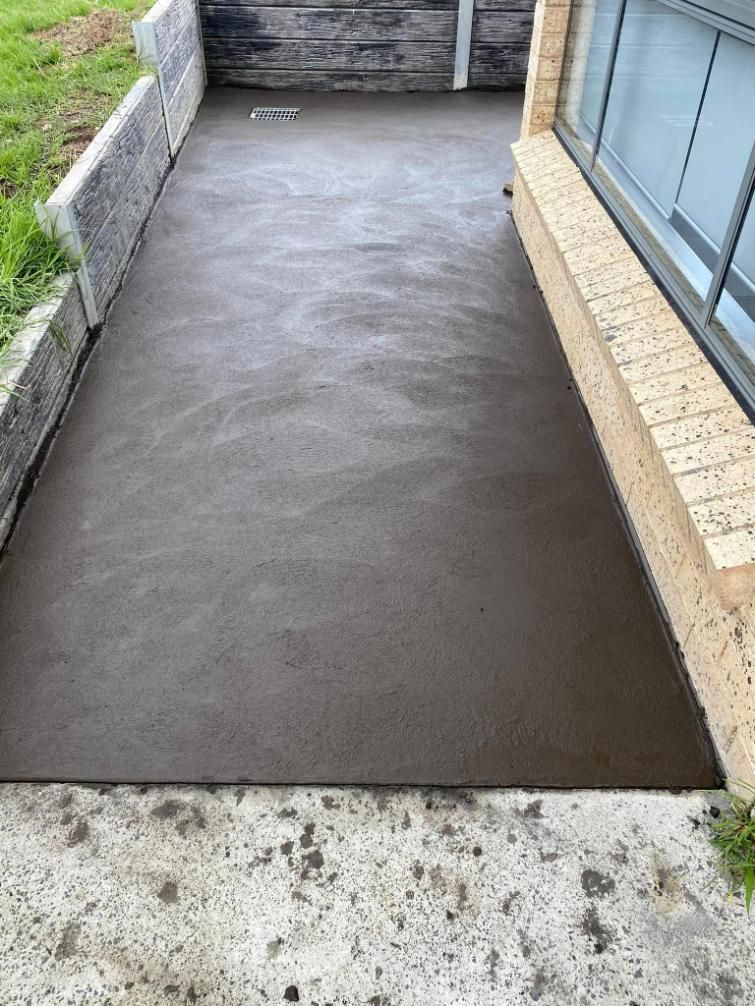 Concrete Walkway is Being Built Next to a Brick Building — BJ's Concreting in Huskisson, NSW
