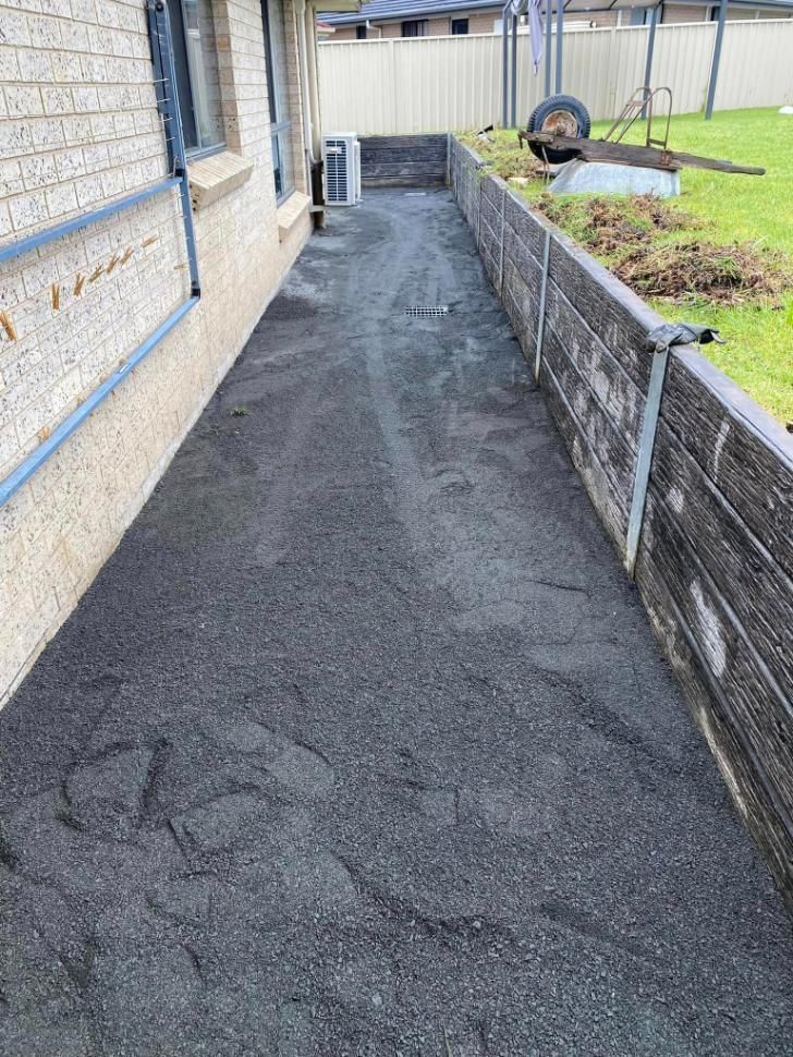 Sidewalk Leading to a House With a Wheelbarrow on the Side of It — BJ's Concreting in Bomaderry, NSW