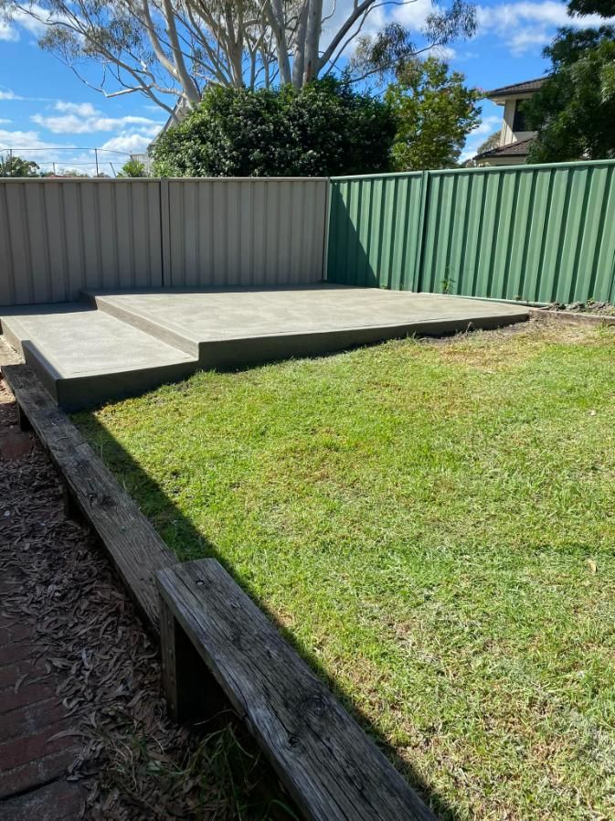 Backyard With a Concrete Patio and a Green Fence — BJ's Concreting in Callala Bay, NSW