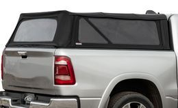 Black truck bed cap on a silver pickup truck; window with mesh.