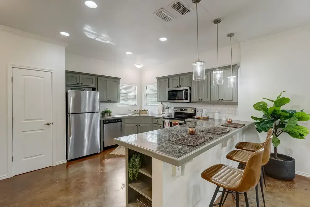A kitchen with stainless steel appliances and granite counter tops.