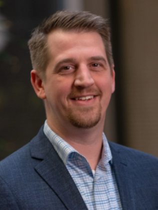 A man in a suit and tie is smiling for the camera.