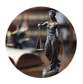 Statue of Lady Justice holding scales, blindfolded, in a law office setting with books.