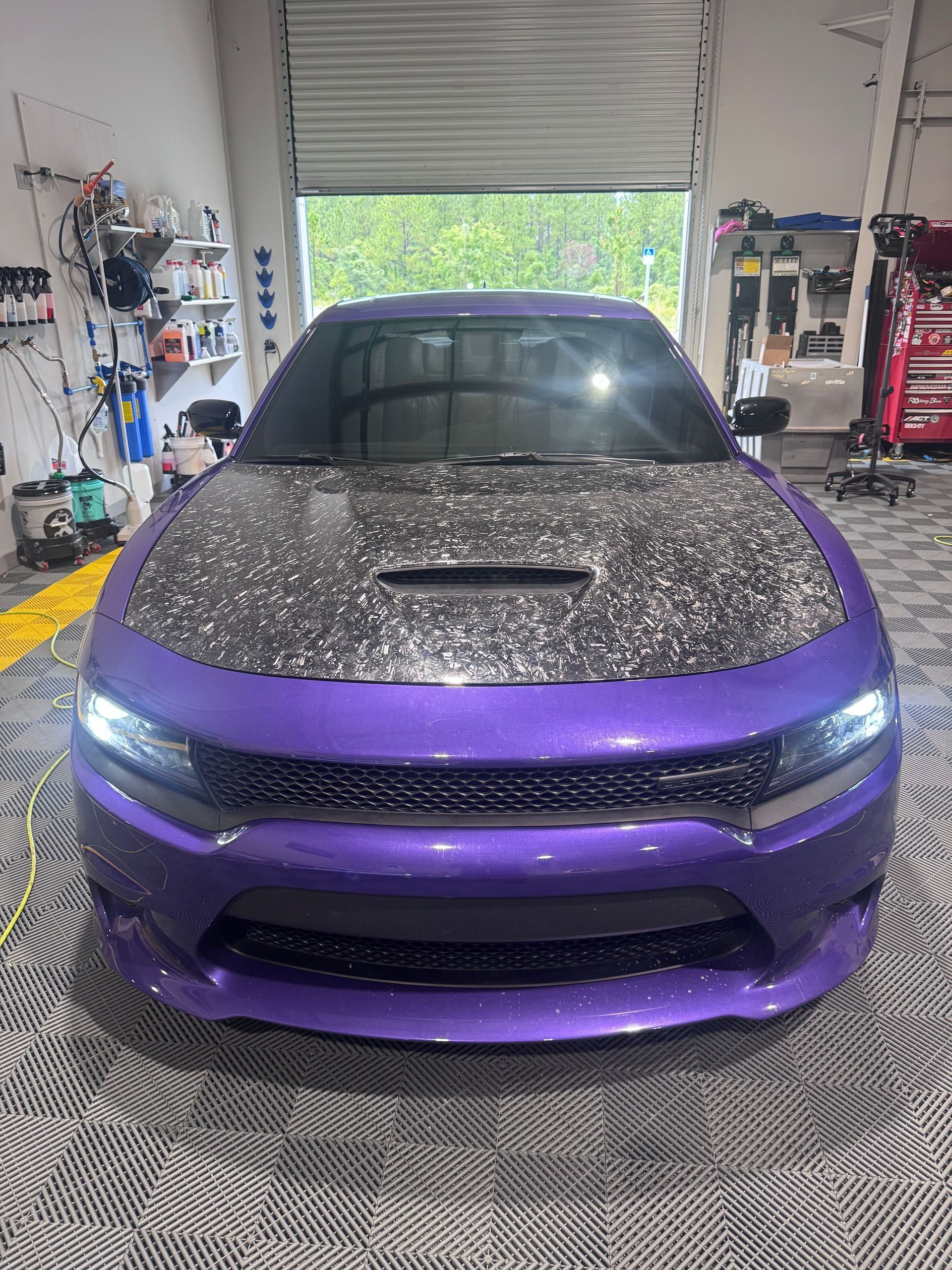 Purple Dodge Charger with textured hood in a workshop.