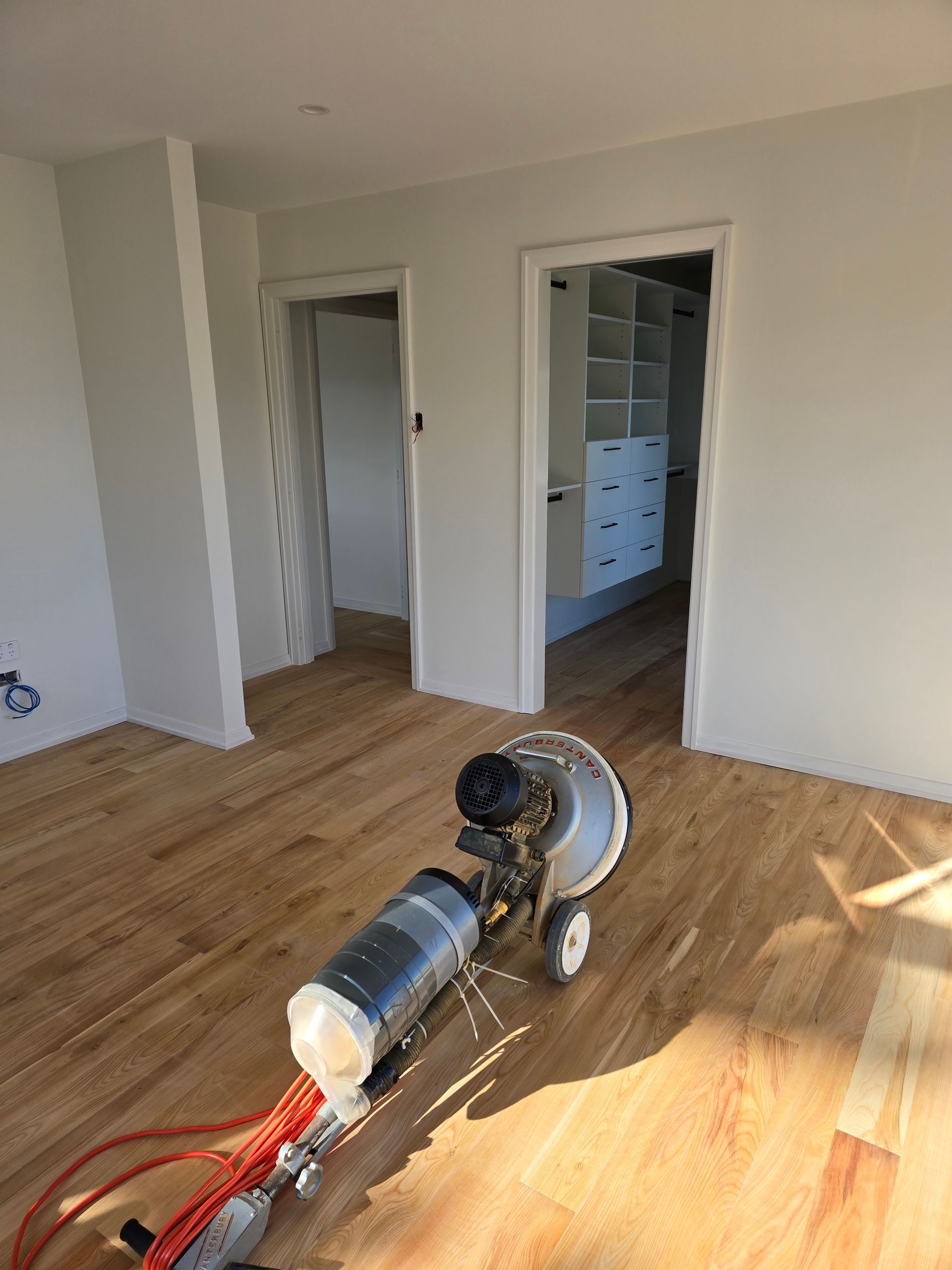 A machine is sitting on a wooden floor in a room.