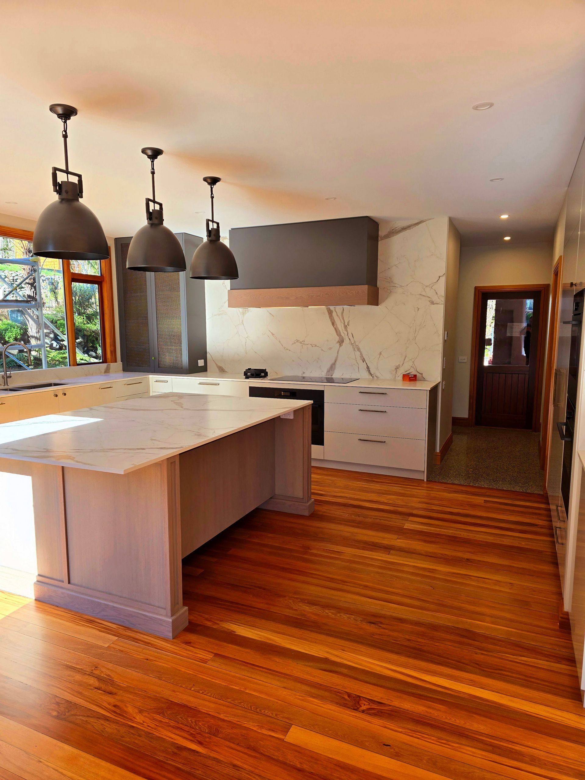 A kitchen with a large island and wooden floors