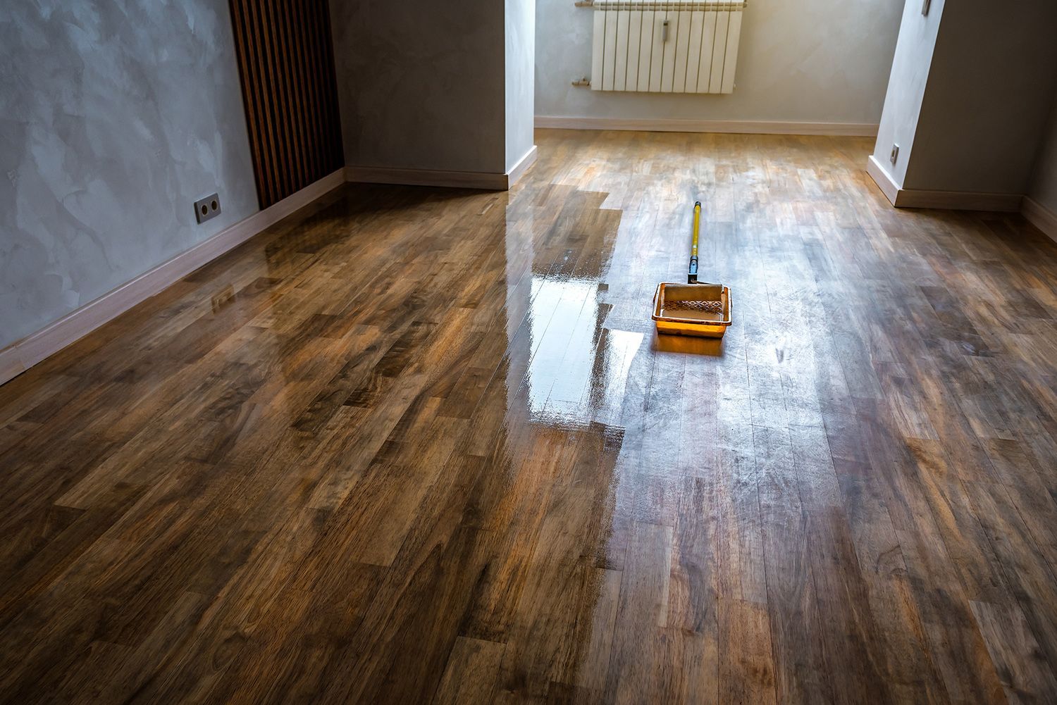A mop is sitting on a wooden floor in a room.