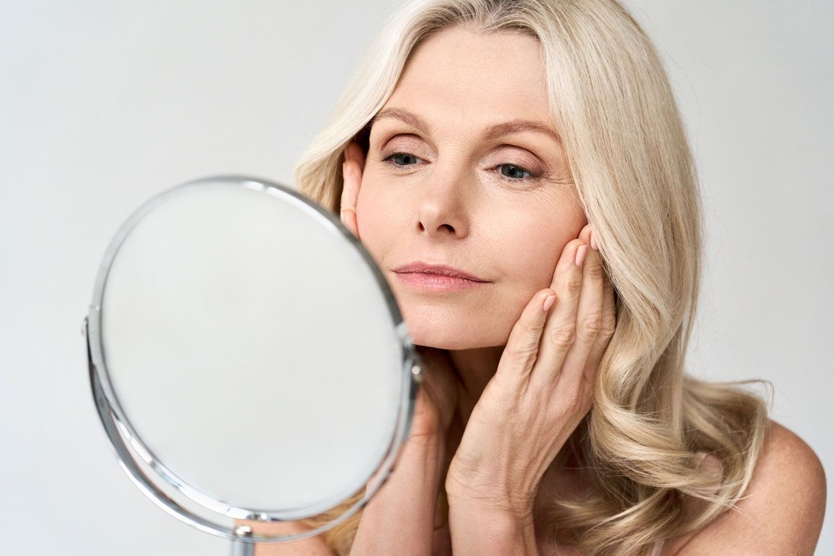 Middle-aged Woman Checking Face on Mirror
