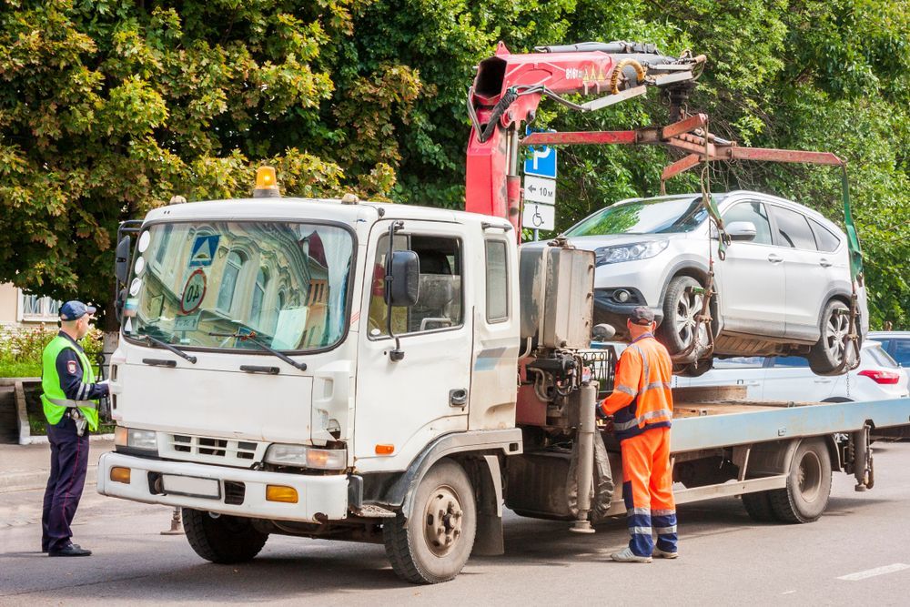A Tow Truck Lifting a White Car — Penfold Towing in Urangan, QLD