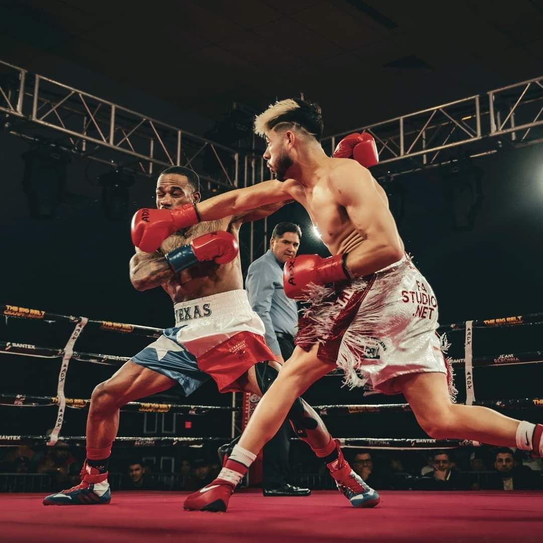 Two boxers trading punches in a boxing ring under bright arena lights