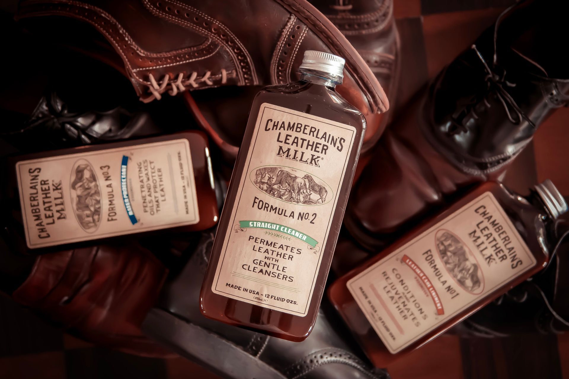 Three bottles of Chamberlain's Leather Milk on leather shoes; dark brown.