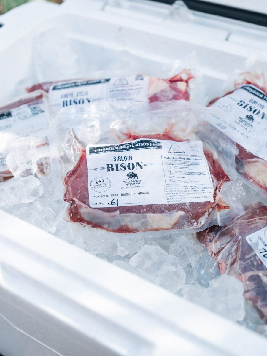 Packaged bison meat in a cooler filled with ice.