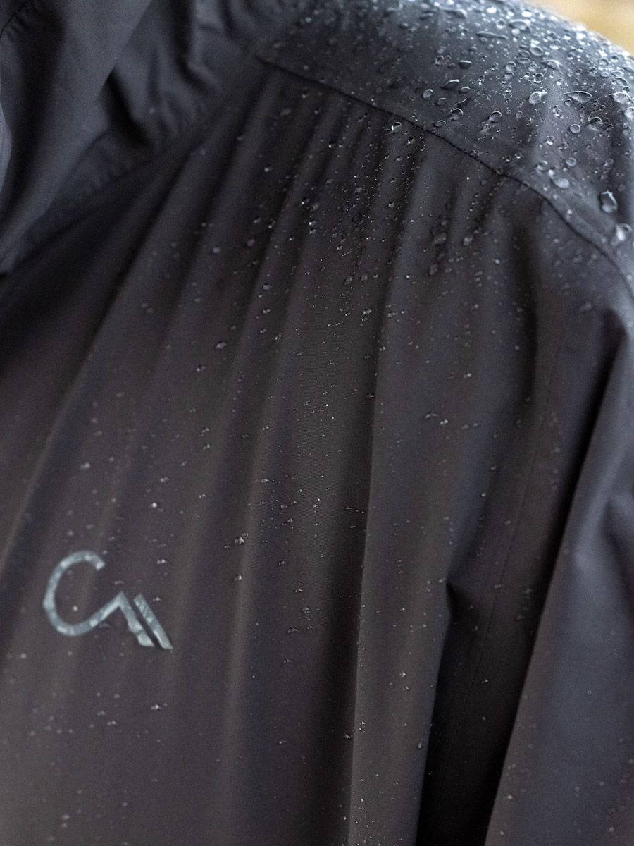 Black jacket with water droplets; small logo on the chest.