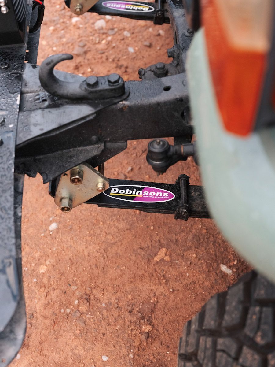 Close-up of a Land Cruiser’s suspension. Black metal components with a pink and white