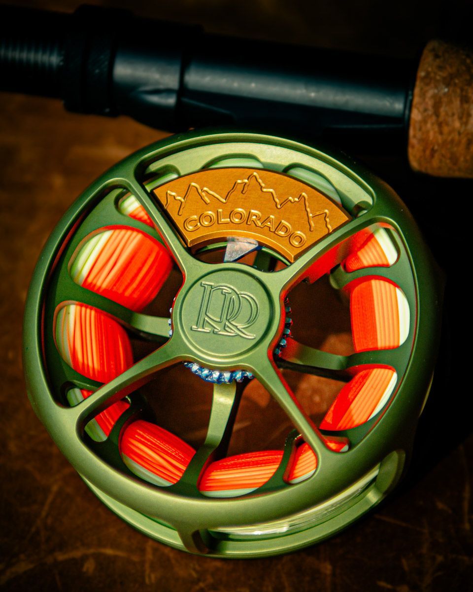 Green fly fishing reel with orange line;