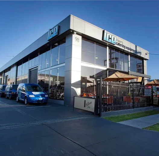 A blue van is parked in front of a building that says ico