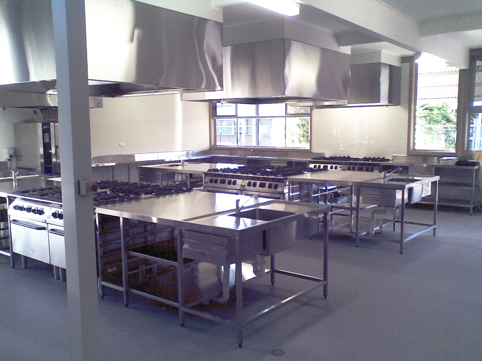 A large kitchen with lots of stainless steel appliances
